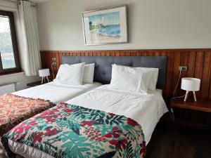 a hotel room with two beds and a quilt at Hotel Boutique Cutipay in Valdivia