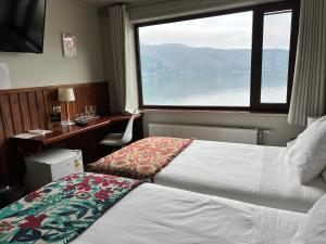 ein Hotelzimmer mit einem Bett und einem Fenster in der Unterkunft Hotel Boutique Cutipay in Valdivia