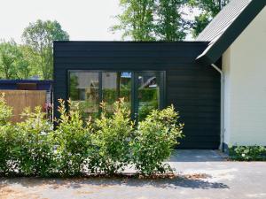 a black house with plants in front of it at Bed & Breakfast Udens Buiten in Veghel