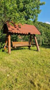 un banco del parque con un techo oxidado en un campo en Cristian, en Dejani