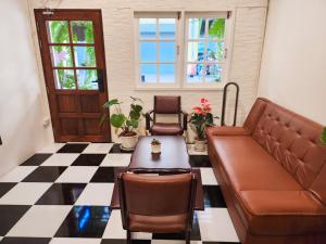 ChinatownNoir Cafe And Hostel Chinatown Bangkok的带沙发和桌子的客厅