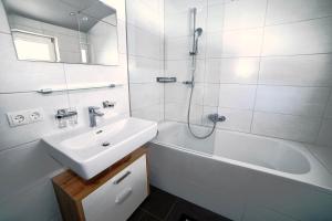 biała łazienka z umywalką, wanną i prysznicem w obiekcie Apartment Krabacher w mieście Seefeld in Tirol +23 zdjęcia