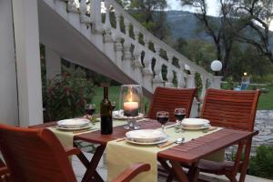 a table with a candle and glasses of wine at Villa Karidia in Asprogerakata