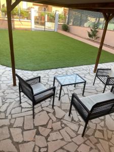 Nuova Gibellina的住宿－Mezz’ora dai mari，庭院里摆放着一组椅子和一张桌子