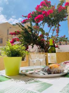 a table with a plate of food and a bottle of wine at El cortijo Bungalow Playa las Americas in Playa de las Americas