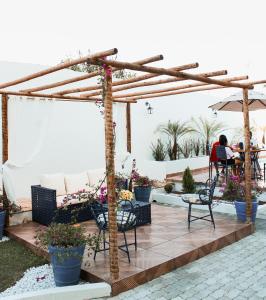 a patio with a wooden pergola and chairs at Pousada Serra Bella in Tianguá