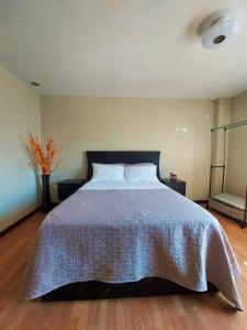 Un dormitorio con una cama grande con un edredón azul. en Casa Mahulu, en Paracas