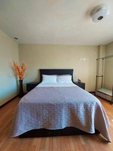 a bedroom with a large bed with a blue comforter at Casa Mahulu in Paracas