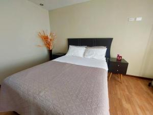 1 dormitorio con 1 cama y un jarrón sobre una mesa en Casa Mahulu, en Paracas