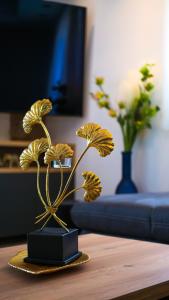 eine Goldpflanze auf einem Tisch im Wohnzimmer in der Unterkunft Luxury penthouse SkyView in Trogir
