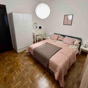 - une chambre avec un lit avec des oreillers roses et un bureau dans l'établissement Amarante apartments, à Kaštela