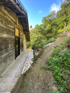 Çaykara的住宿－أوزونغول Uzongol Fotinos Wooden Cottage Two Bedroom，一条空路径,位于带门的建筑物旁边