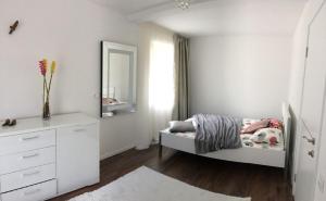 ボーヒニにあるLuxury Apartment near Lake Bohinjの白いベッドルーム(ベッド1台、鏡付)