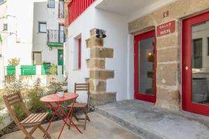 patio con mesa, sillas y puerta roja en Apartamento Basartena I Puerto Viejo, en Getxo