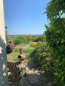 un vaso seduto accanto a una panchina in un giardino di The Garage Getaway a Glastonbury