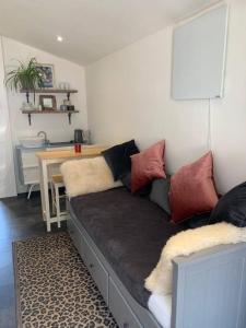 a couch with pillows on it in a living room at The Garage Getaway in Glastonbury