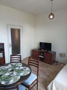 een woonkamer met een tafel en stoelen en een televisie bij Welcome to Daisy sunny place! in Varna