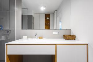 a bathroom with a sink and a mirror at Wave9 - Monte Cassino by OneApartments in Sopot