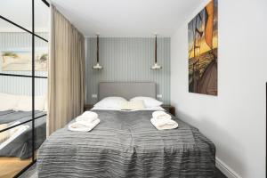 a bedroom with a bed with towels on it at Wave9 - Monte Cassino by OneApartments in Sopot