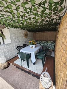 un patio con una mesa con sillas y flores. en La Casuca De Mabel en Revilla de Camargo