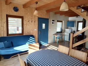 a living room with a blue couch and a kitchen at Domek Smerfna Chatka in Wąglikowice