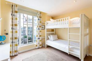 een slaapkamer met 2 stapelbedden en een raam bij Luxury and Modern Bayswater Apartment in Londen