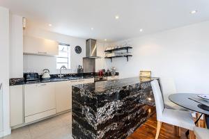 een keuken met een aanrecht en een tafel bij Luxury and Modern Bayswater Apartment in Londen