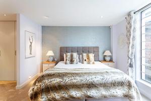 een slaapkamer met een groot bed en 2 lampen bij Luxury and Modern Bayswater Apartment in Londen