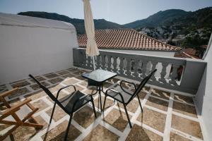 a balcony with chairs and a table and a view at Gelhaus 1935 in Hydra
