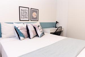 una camera da letto con letto, lenzuola e cuscini bianchi di 360 Santa Ifigênia a San Paolo