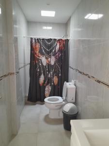 a bathroom with a toilet and a shower curtain at Hermoso departamento. Todo equipado. Zona norte in Puerto Madryn