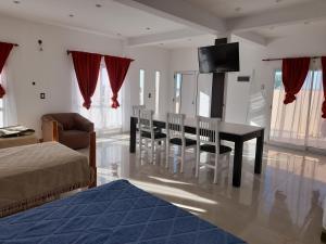 a living room with a table and chairs and a television at Hermoso departamento. Todo equipado. Zona norte in Puerto Madryn