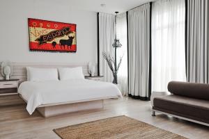 a white bedroom with a bed and a couch at Bungalow Hotel in Long Branch