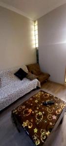a room with a bed and a table with a couch at Balavari Samgori Guest House in Tbilisi City