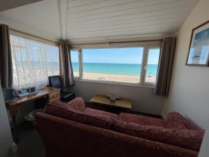 een woonkamer met een bank en uitzicht op het strand bij Navigator Hotel in Bognor Regis