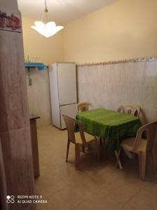 uma cozinha com uma mesa e cadeiras e um frigorífico em Grand appartement à deux pas de la plage em Souira Guedima