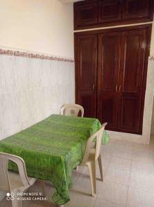 um quarto com uma mesa e cadeiras e uma porta em Grand appartement à deux pas de la plage em Souira Guedima