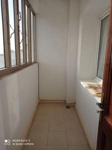 um corredor vazio com uma porta e uma janela em Grand appartement à deux pas de la plage em Souira Guedima