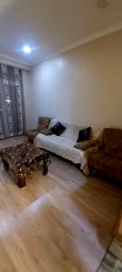 a living room with a couch and a coffee table at Balavari Samgori Guest House in Tbilisi City