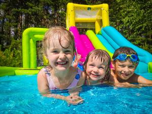 een groep van drie kinderen in een zwembad bij Chata Leśna Polana in Kurzętnik