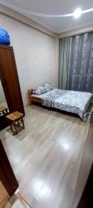 a bedroom with a bed and a wooden floor at Balavari Samgori Guest House in Tbilisi City