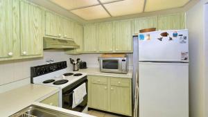 a kitchen with a white refrigerator and a microwave at 6415 Midnight Pass #307 in Siesta Key