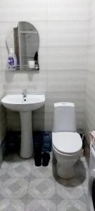 a bathroom with a white toilet and a sink at Balavari Samgori Guest House in Tbilisi City