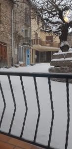 uma casa com uma porta azul na neve em Maison proche de la nature em Quérigut