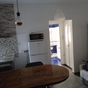 uma cozinha com uma mesa e um frigorífico em Spacious apartment in center of Agia Napa em Agia Napa