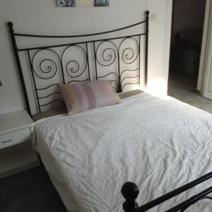 uma cama com lençóis brancos e uma cabeceira preta em Spacious apartment in center of Agia Napa em Agia Napa