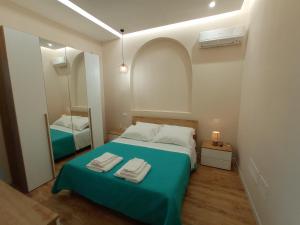 a small bedroom with a bed and a mirror at Suites Elifani Marina in Trani