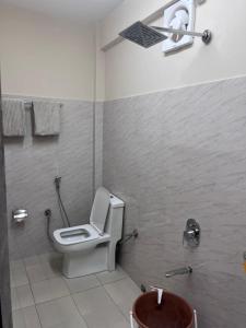 a bathroom with a toilet and a sink at Joyous Rooms in Cherrapunji