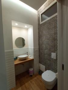 a bathroom with a white toilet and a sink at Suites Elifani in Trani