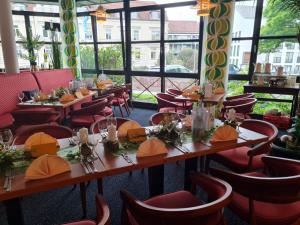 un restaurante con mesas, sillas y ventanas en Grandhotel Esplanade en Bad Nenndorf